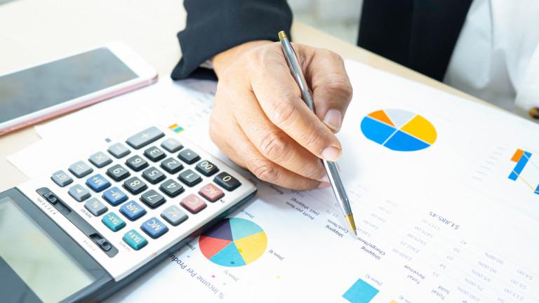 Asian accountant working and analyzing financial reports project accounting with chart graph and calculator in modern office, finance and business concept.